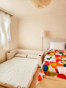 首尔Dohwa Stay - New Open AREX, 3mins to Gongdeok Station的一间卧室配有一张带五颜六色被子的床