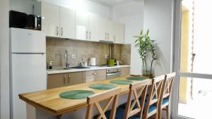a kitchen with a wooden table with chairs and a refrigerator at DUPLEX BELLE VIEW SINAIA-free parking in Sinaia