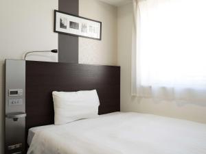 a bedroom with a white bed with a large window at Comfort Hotel Tokyo Kanda in Tokyo