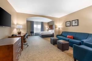 a living room with a blue couch and a bedroom at Comfort Inn & Suites Tavares North in Tavares