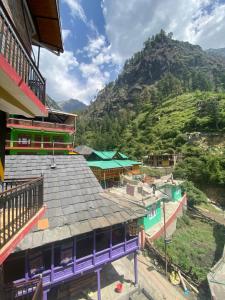 a view of a building with a mountain in the background at Pahadirovers Homestay & Cafe in Kasol