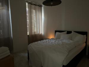 a bedroom with a white bed with a light on it at Casa Noelia & Dairi in Biel