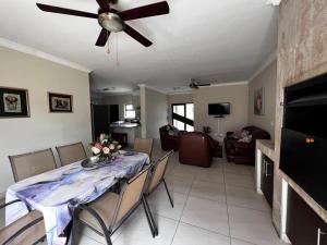 a living room with a table with chairs and a ceiling fan at The Lofty-Nest of Leadwood Street in Swakopmund