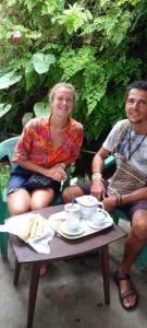 ein Mann und eine Frau sitzen um einen Tisch in der Unterkunft Shine View in Dikwella