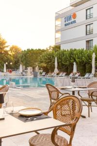 a patio with tables and chairs next to a swimming pool at Sun Beach Hotel in Agia Triada +31 photos