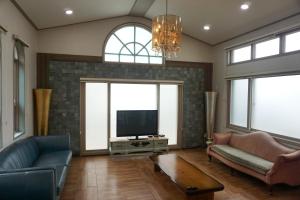 ein Wohnzimmer mit Sofa und Fernseher in der Unterkunft tebaz in Jeju-do