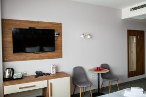 a room with two chairs and a television on a wall at BG Hotel in Sofia