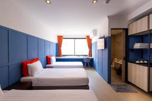 a room with two beds and a blue wall at Penpark Place in Bangkok