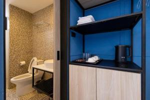 a small bathroom with a toilet and blue walls at Penpark Place in Bangkok +37 photos