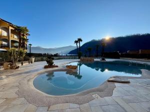 a large pool in a courtyard with a resort at Yachting Residence in Lavena Ponte Tresa +107 photos