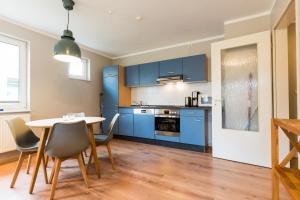 a kitchen with blue cabinets and a table and chairs at Tante Schmidt 1 in Staberdorf