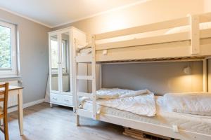 a bedroom with two bunk beds and a desk at Tante Schmidt 1 in Staberdorf