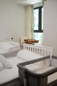 une chambre avec deux lits et une chaise et une fenêtre dans l'établissement Kid-Loving Poolside Haven - 2BR - Netflix - Games, à Johor Bahru