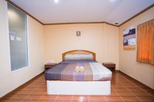 a bedroom with a bed with two slippers on it at M.P Resort in Ao Nam Mao