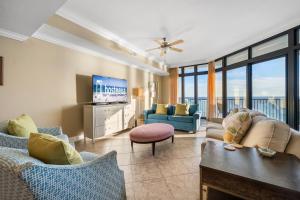 a living room with couches and a flat screen tv at Oasis at Orange Beach 1102 in Orange Beach