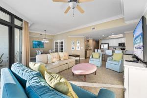 a living room with a blue couch and a tv at Oasis at Orange Beach 1102 in Orange Beach +52 photos