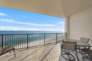 a balcony with a table and chairs and the ocean at Oasis at Orange Beach 1102 in Orange Beach