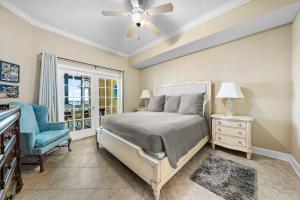 a bedroom with a bed and a chair and a window at Oasis at Orange Beach 1102 in Orange Beach