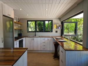 a large kitchen with wooden cabinets and two windows at Island Lake Villa and Bungalow in Wilderness