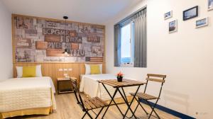 a bedroom with two beds and a table and a window at Ocean Star B&B in Kenting