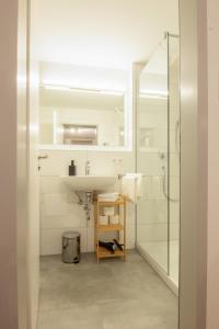 a white bathroom with a sink and a shower at Apartmenthaus Markdorf in Markdorf +63 photos