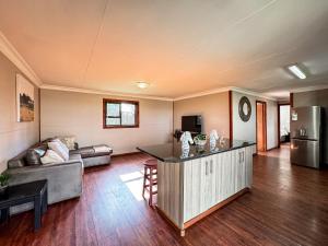 a large living room with a couch and a kitchen at Kings 93 Cabins in Tierpoort