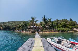 a boat is docked at a dock in the water at Markatis House with views to Corfu east in Káto Spílaion