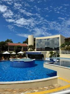 a large pool with blue water in front of a building at Solar Agua Pipa in Pipa
