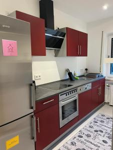 a kitchen with red cabinets and stainless steel appliances at Ferienwohnung Mobembo in Konz +13 photos