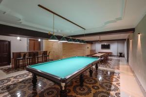 タシュケントにあるSofiya Tashkent Hotelのテーブルと椅子付きの部屋のビリヤード台