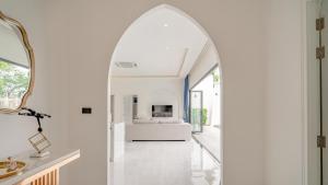 an arched doorway leads to a living room with a fireplace at Bang Tao Villa - Menara Hill in Phuket Town