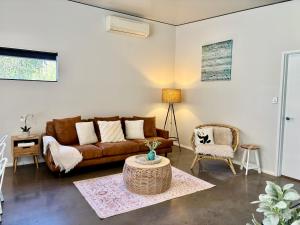 a living room with a couch and a table at Panda's Patch Dunsborough in Dunsborough