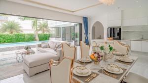 a dining room and living room with a table and chairs at Bang Tao Villa - Menara Hill in Phuket Town