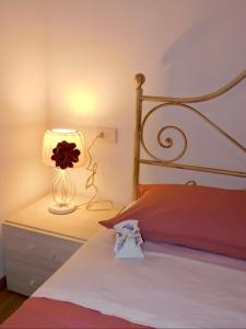 a bedroom with a bed and a lamp on a night stand at b&b Tati in Sedico