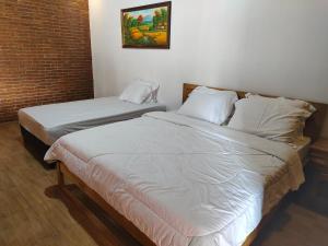two twin beds in a room with at Kampoeng Sekuro in Jepara
