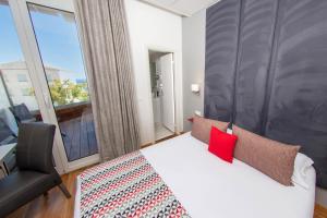 a bedroom with a bed and a large window at Hôtel Méditerranée in Calvi