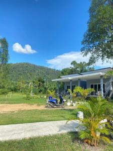 a motorcycle parked in front of a house at Maisuree Lanta Resort-Long Beach in Ko Lanta