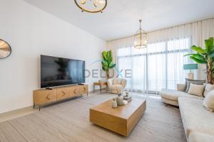 a living room with a tv and a couch and a coffee table at Elegant 4BR Villa with Assistant Room in Al Dana Island, Sharm, Fujairah by Deluxe Holiday Homes in Fujairah