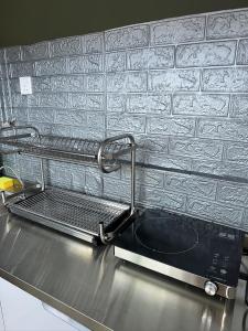 a kitchen counter with a sink and a microwave at Catus Theme Walk Up Apartment Matang in Kuching