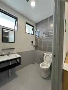 a bathroom with a toilet and a sink at Catus Theme Walk Up Apartment Matang in Kuching