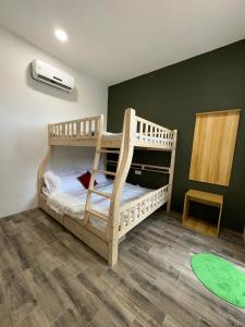 a bunk bed in a room with a green wall at Catus Theme Walk Up Apartment Matang in Kuching