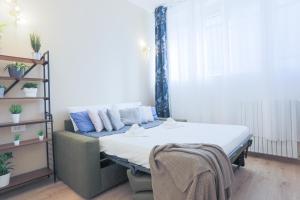 Habitación con cama, sofá y ventana en Prada-IEO-Bocconi-Wi-fi free-AC-Private Parking, en Milán 23 fotos más
