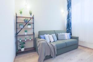 una sala de estar con sofá y estanterías con plantas en Prada-IEO-Bocconi-Wi-fi free-AC-Private Parking, en Milán
