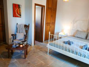 a bedroom with a bed and a chair and a table at Skarinou Panorama Room in Skarinou