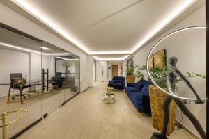 a living room with a blue couch and a mirror at Gold Suites in Ioannina