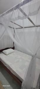 a white bed with a canopy in a room at Niro House and Restaurant in Ahangama