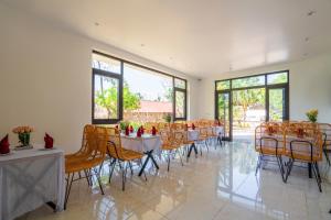 a dining room with tables and chairs and windows at Rocky Mountain Homestay Cat Ba in Cat Ba