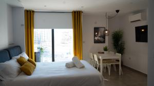 a bedroom with a bed and a table and a window at E1 Suites & Spa aparthotel style - Gym & Spa in Gibraltar