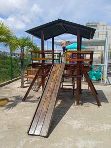 un patio de recreo con un tobogán de madera en un parque en Apto mobiliado e aconchegante - 3 quartos, 4 camas, 2 banheiros - Lazer completo e localização privilegiada, en João Pessoa