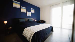 una camera blu con un letto e una grande finestra di Villa Suarticcia, 6 pers, piscine chauffée, 3 min plage en voiture a Sainte-Lucie de Porto-Vecchio